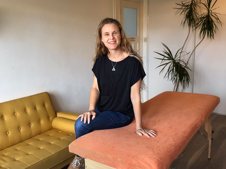Haptotherapeut bij de behandeltafel nodigt je uit voor een kennismakingsessie haptotherapie